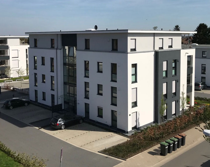 Modernes Mehrfamilienhaus mit 2-farbiger Fassade und Lofts im Dachgeschoss